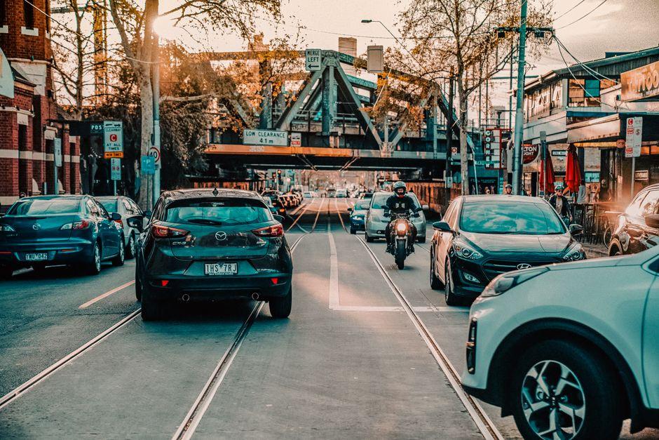 Traffic on Street with Truss Bridge over